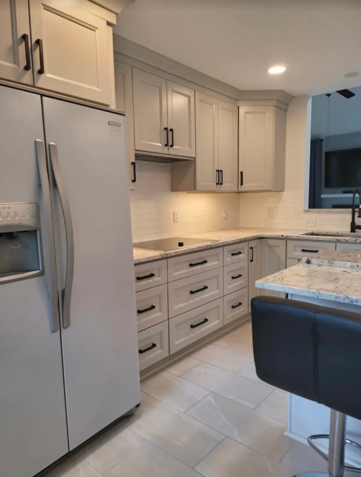 Kitchen remodel with shaker cabinets, granite countertops, island, and tile flooring