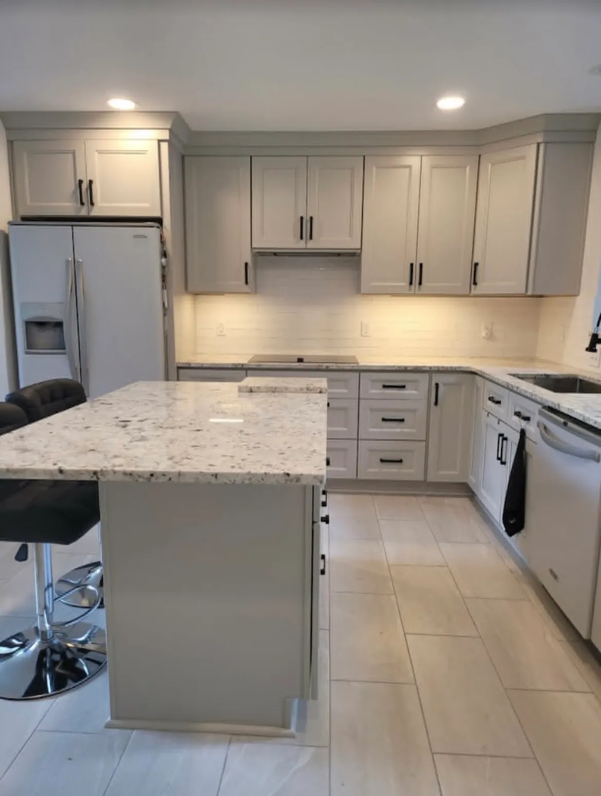 Kitchen remodel with light shaker cabinets, granite countertops, and black cabinet hardware