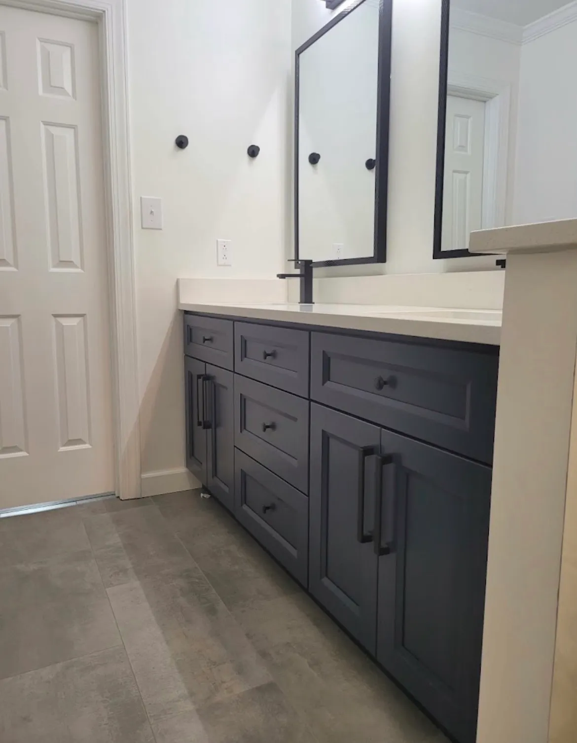 Navy blue bathroom vanity with white countertop and black hardware