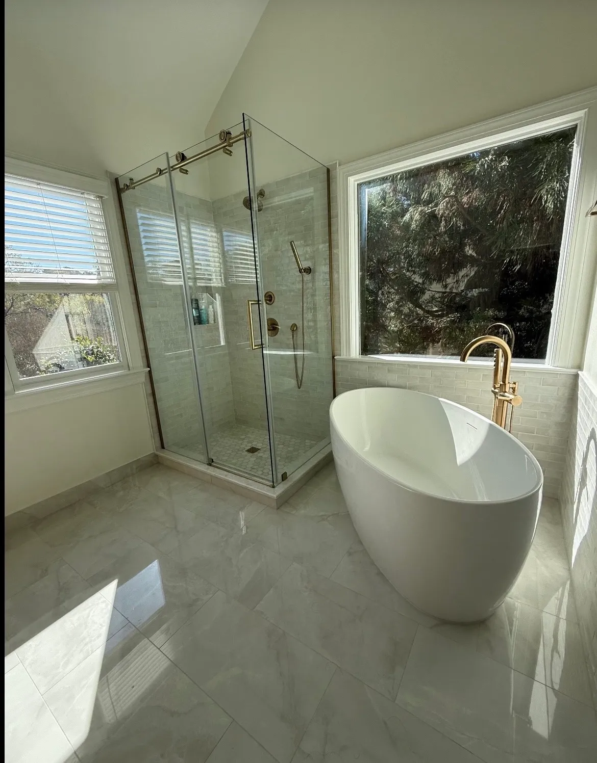 Completed bathroom with a glass shower and freestanding tub