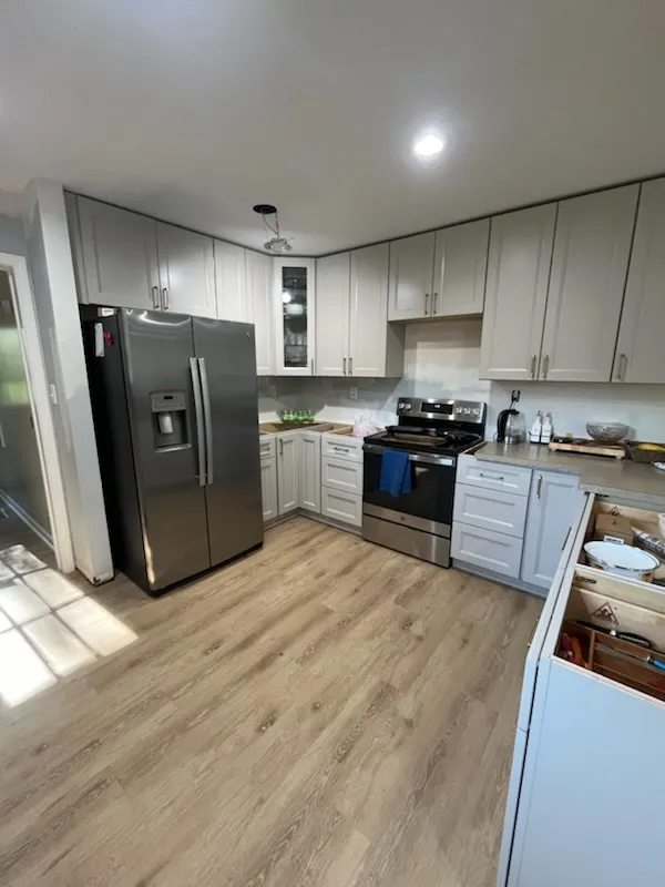 Gray kitchen cabinets along the refrigerator wall